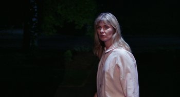 Movie still from “Rachel, Rachel” (1968), directed by Paul Newman – A woman standing in the dark wearing a white shirt; Medium shot, Low angle