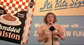 Movie still from “Radio Days” (1987), directed by Woody Allen – A young girl in a pink dress is holding a microphone; Medium shot, Low angle