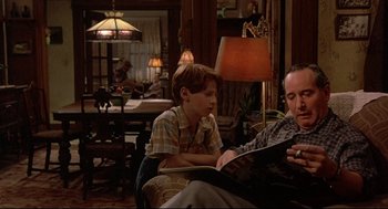 Movie still from “Radio Days” (1987), directed by Woody Allen – A man and a boy sitting in a living room; Medium shot, Low angle