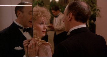Movie still from “Radio Days” (1987), directed by Woody Allen – A man and a woman looking at each other in front of a mirror; Close Up shot, Over the shoulder angle