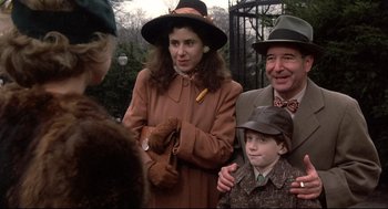 Movie still from “Radio Days” (1987), directed by Woody Allen – A woman and a man standing next to a child; Medium shot, Over the shoulder angle