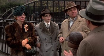 Movie still from “Radio Days” (1987), directed by Woody Allen – A group of people standing next to each other wearing hats; Medium shot, Over the shoulder angle