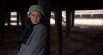 Movie still from “Radio Days” (1987), directed by Woody Allen – A young girl wearing a green hat and a scarf; Medium shot, Over the shoulder angle