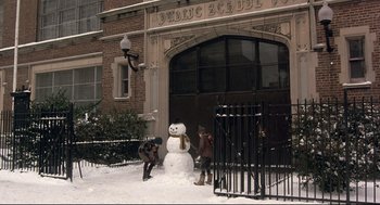 Movie still from “Radio Days” (1987), directed by Woody Allen – Two children playing with a snowman outside a building; Extreme Wide shot, High angle