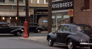 An old car is parked on the side of the street