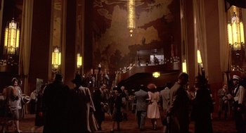Movie still from “Radio Days” (1987), directed by Woody Allen – A group of people walking down a hall of a building; Extreme Wide shot, Low angle