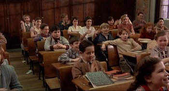 Movie still from “Radio Days” (1987), directed by Woody Allen – A group of people sitting in a classroom; Wide shot, High angle