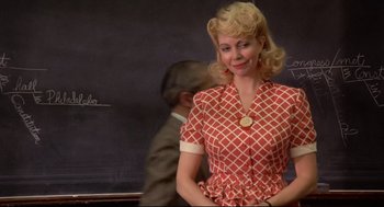 Movie still from “Radio Days” (1987), directed by Woody Allen – A woman in a red and white checkered dress standing in front of a man; Medium shot, Low angle