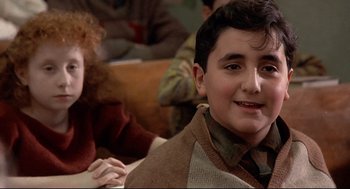 Movie still from “Radio Days” (1987), directed by Woody Allen – A young boy sitting in front of a woman; Close Up shot, Over the shoulder angle