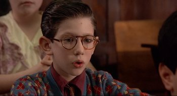Movie still from “Radio Days” (1987), directed by Woody Allen – A young boy wearing glasses and a sweater; Close Up shot, High angle