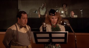 Movie still from “Radio Days” (1987), directed by Woody Allen – A woman is singing in front of a microphone; Medium shot, Low angle