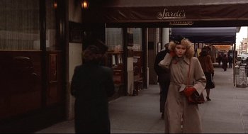 Movie still from “Radio Days” (1987), directed by Woody Allen – A woman in a trench coat talking on a phone; Wide shot, Over the shoulder angle