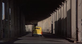 Movie still from “Radio Days” (1987), directed by Woody Allen – A yellow car parked under a bridge in the dark; Extreme Wide shot, Low angle