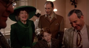 Movie still from “Radio Days” (1987), directed by Woody Allen – A group of people standing next to each other in a room; Medium shot, Over the shoulder angle