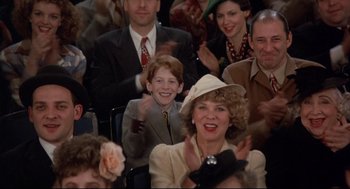 Movie still from “Radio Days” (1987), directed by Woody Allen – A group of people sitting in a crowd clapping; Medium shot, Over the shoulder angle