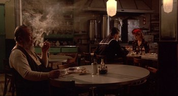 Movie still from “Radio Days” (1987), directed by Woody Allen – People sitting at a table in a restaurant with smoke billowing out of the ceiling; Medium shot, Over the shoulder angle