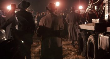 Movie still from “Radio Days” (1987), directed by Woody Allen – A group of people standing in a field at night; Wide shot, Over the shoulder angle