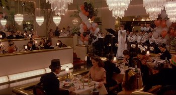 Movie still from “Radio Days” (1987), directed by Woody Allen – A group of people sitting at a table in a restaurant; Wide shot, High angle