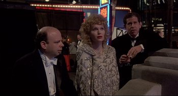 Movie still from “Radio Days” (1987), directed by Woody Allen – A woman standing next to two other men; Medium shot, Over the shoulder angle