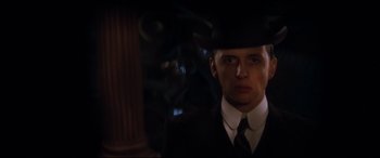 Movie still from “Ragtime” (1981), directed by Milos Forman – A man in a suit and hat is looking at the camera; Close Up shot, Low angle