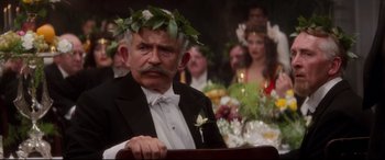 Movie still from “Ragtime” (1981), directed by Milos Forman – An old man wearing a wreath of flowers; Close Up shot, Over the shoulder angle