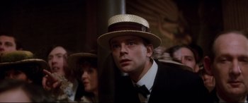 Movie still from “Ragtime” (1981), directed by Milos Forman – A man wearing a straw hat and a black suit; Close Up shot, Low angle