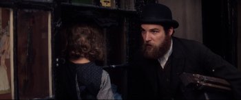 Movie still from “Ragtime” (1981), directed by Milos Forman – A man with a long beard wearing a black hat; Close Up shot, Over the shoulder angle