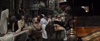 Movie still from “Ragtime” (1981), directed by Milos Forman – A group of people standing on a city street; Wide shot, High angle