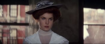 Movie still from “Ragtime” (1981), directed by Milos Forman – A young woman wearing a hat and a white dress; Close Up shot, Over the shoulder angle