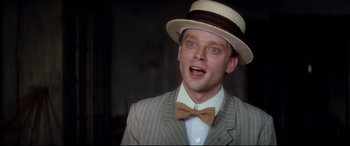 Movie still from “Ragtime” (1981), directed by Milos Forman – A man wearing a hat and a bow tie; Close Up shot, Low angle