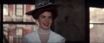Movie still from “Ragtime” (1981), directed by Milos Forman – A young woman wearing a white dress and a gray hat; Close Up shot, Over the shoulder angle