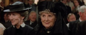 Movie still from “Ragtime” (1981), directed by Milos Forman – An older woman wearing a black dress and a black hat; Close Up shot, Over the shoulder angle