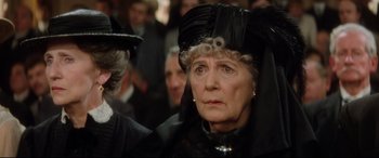 Movie still from “Ragtime” (1981), directed by Milos Forman – An older woman wearing a black dress and a black hat; Close Up shot, Over the shoulder angle