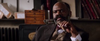 Movie still from “Ragtime” (1981), directed by Milos Forman – A man in a suit and tie holding a cigar in his mouth; Close Up shot, Low angle