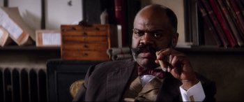 Movie still from “Ragtime” (1981), directed by Milos Forman – A man in a suit and bow tie holding a cigar; Close Up shot, Low angle