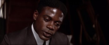 Movie still from “Ragtime” (1981), directed by Milos Forman – A person wearing a suit and tie; Close Up shot, High angle