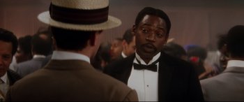 Movie still from “Ragtime” (1981), directed by Milos Forman – A man in a suit and hat talking to another man in a suit and hat; Close Up shot, Over the shoulder angle