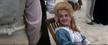 Movie still from “Ragtime” (1981), directed by Milos Forman – A woman with long blonde hair sitting on a chair; Close Up shot, Over the shoulder angle