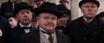 Movie still from “Ragtime” (1981), directed by Milos Forman – An old man with a mustache wearing a suit and a hat; Close Up shot, Low angle