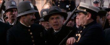 Movie still from “Ragtime” (1981), directed by Milos Forman – A group of men in uniforms and hats holding a gun; Close Up shot, Low angle