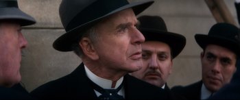Movie still from “Ragtime” (1981), directed by Milos Forman – A man in a suit and a man in a hat; Close Up shot, Low angle