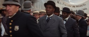 Movie still from “Ragtime” (1981), directed by Milos Forman – A group of men in suits and hats talking to each other; Close Up shot, Over the shoulder angle