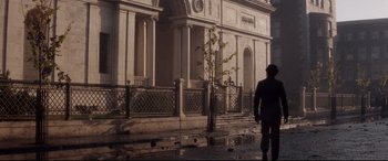 Movie still from “Ragtime” (1981), directed by Milos Forman – A person walking down a street near a building; Extreme Wide shot, Low angle