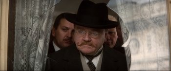 Movie still from “Ragtime” (1981), directed by Milos Forman – An old man with a mustache wearing a suit and a hat; Close Up shot, Low angle