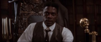 Movie still from “Ragtime” (1981), directed by Milos Forman – A man wearing a suit and tie in front of a mirror; Close Up shot, Low angle