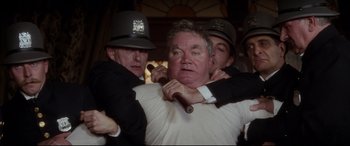 Movie still from “Ragtime” (1981), directed by Milos Forman – A group of men holding a man with a baseball bat over him; Medium shot, Low angle