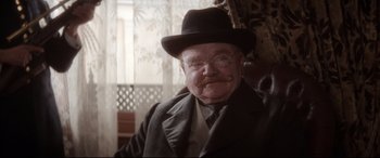 Movie still from “Ragtime” (1981), directed by Milos Forman – An old man with a mustache wearing a hat and glasses; Close Up shot, Low angle