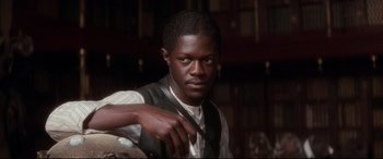 Movie still from “Ragtime” (1981), directed by Milos Forman – A man in a vest is holding a knife in his right hand; Close Up shot, Low angle