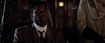 Movie still from “Ragtime” (1981), directed by Milos Forman – A man wearing a suit and tie looking up; Close Up shot, Low angle