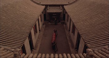 Movie still from “Raise the Red Lantern” (1991), directed by Yimou Zhang – An aerial view of a courtyard with a person walking by it; Extreme Wide shot, High angle